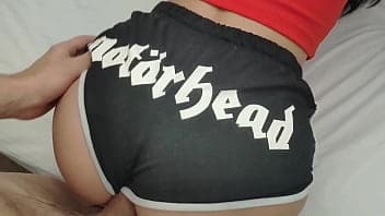Een sexy tienerbek in een korte broek berijdt een pik en slikt sperma door.
